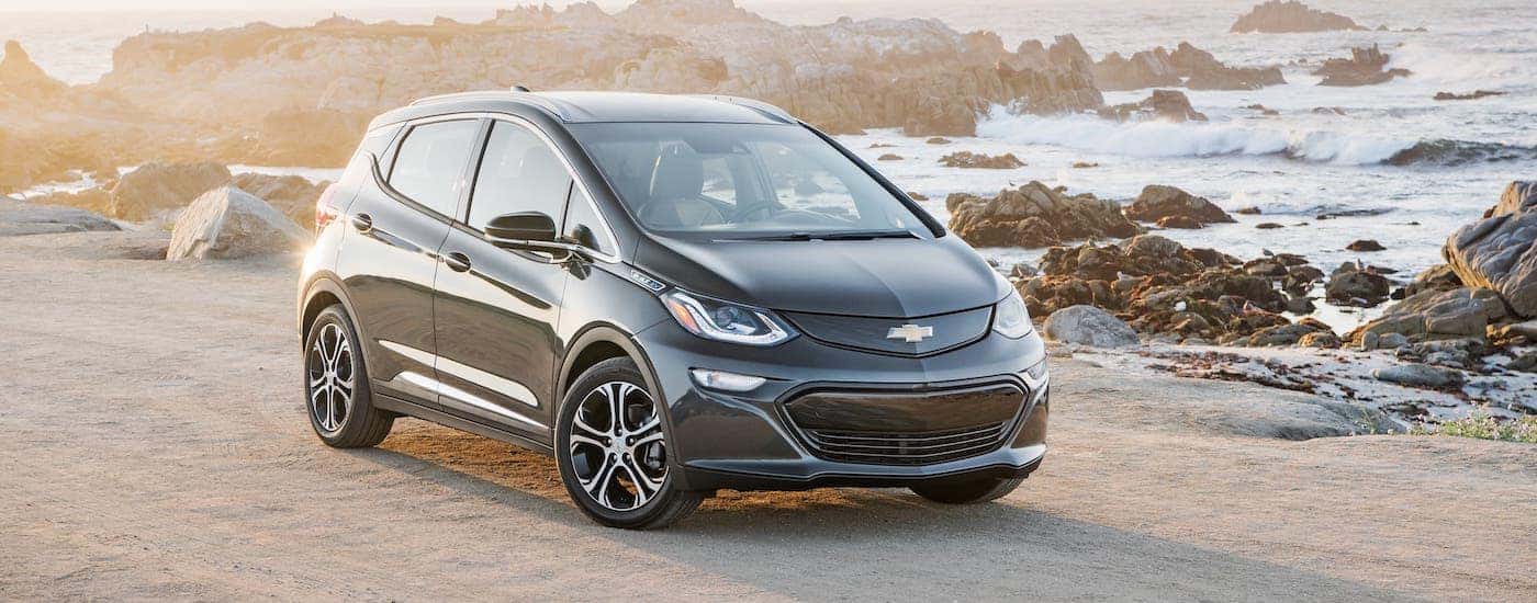 A black 2021 Chevy Bolt EV is parked on a beach.