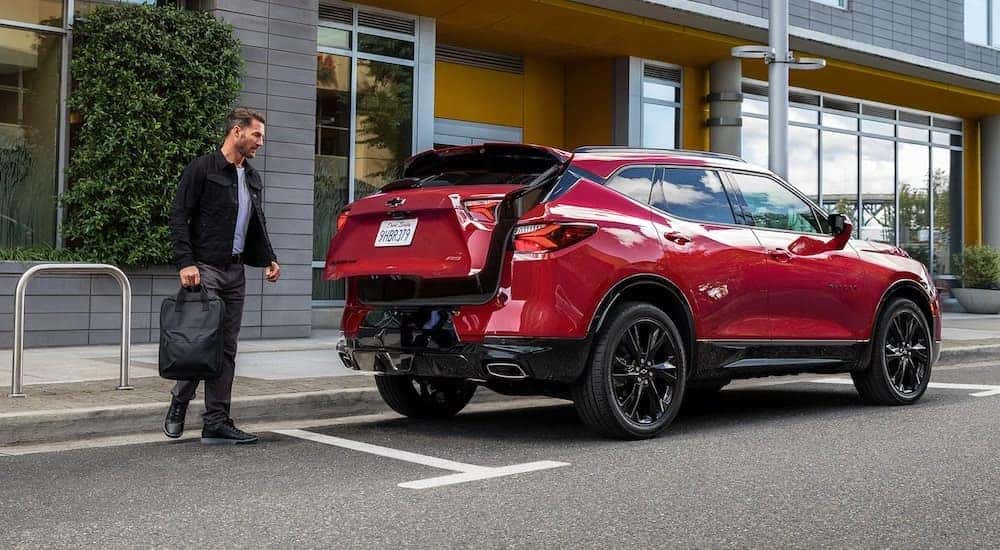A red 2021 Chevy Blazer RS is shown from behind with luggage being packed in the trunk.