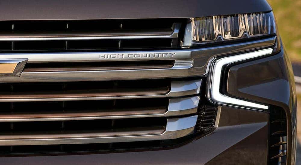 A close up shows the grille and driver side headlight on a grey 2021 Chevy Tahoe High Country.