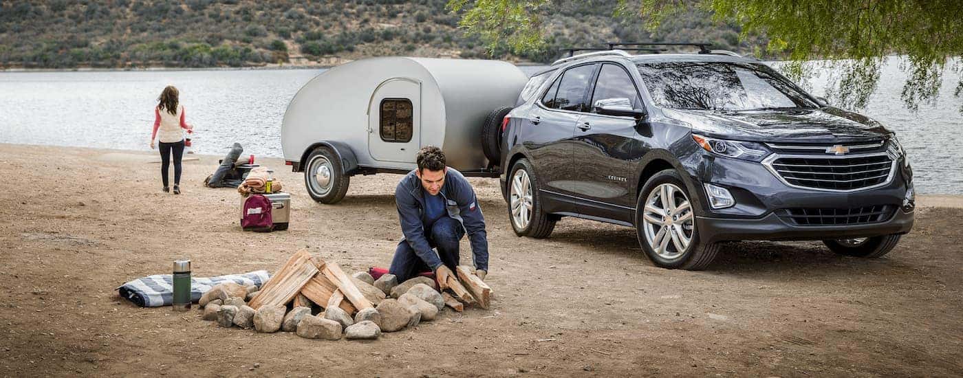 A dark blue 2020 Chevy Equinox is shown parked at a campsite.