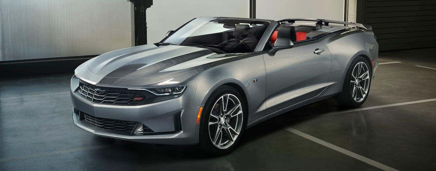 A silver 2021 Chevy Camaro convertible is parked in a garage after leaving a Chevy dealer near Troy.