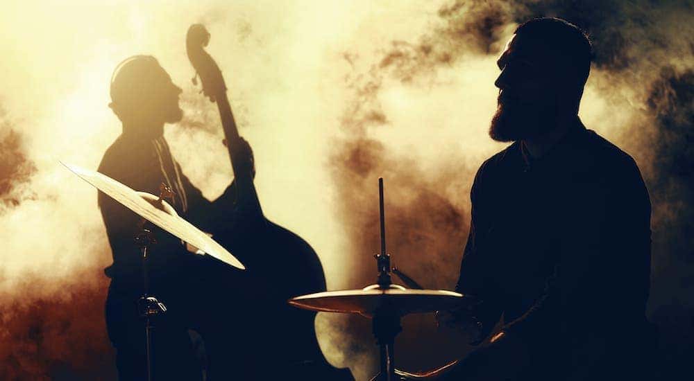 Two musician silhouettes are shown against a smokey background.