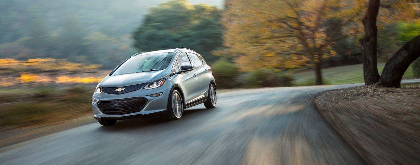 A pale blue 2017 Chevy Bolt EV is shown rounding a corner.