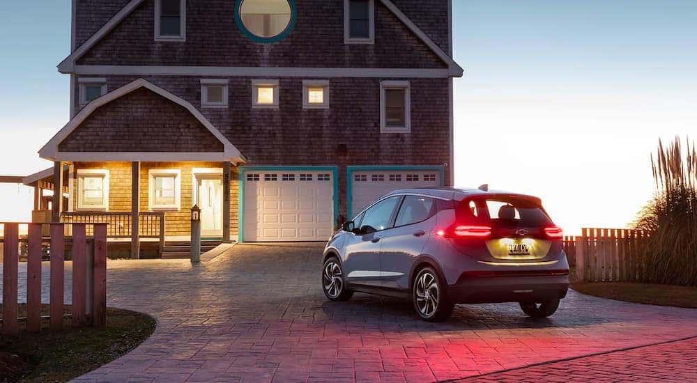 A silver 2022 Chevy Bolt EV is shown from behind parked in a driveway.