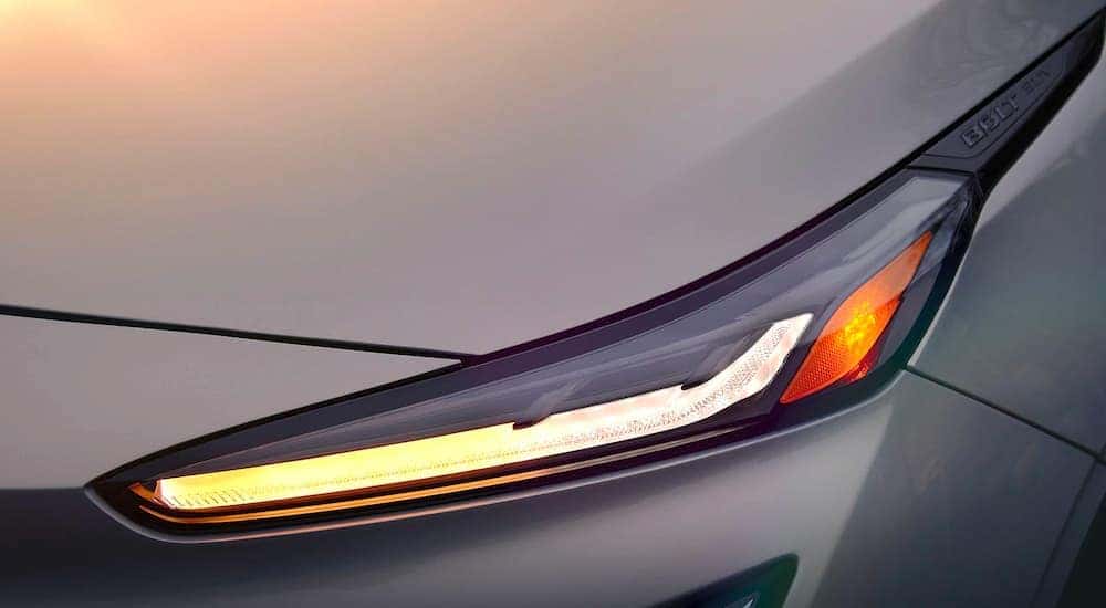 A close up shows the headlight of a 2022 Chevy EUV after leaving an Albany electric car dealer.