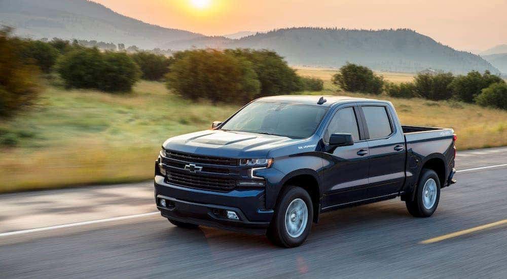 A blue 2020 Chevy Silverado 1500 is driving down an open road.