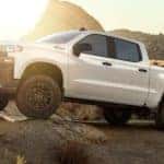 A white 2020 Chevy Silverado 1500 is parked on rocks.
