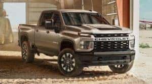 A tan 2021 Chevy Silverado 2500HD is shown in a barn after leaving a dealership who specializes in NY Chevy truck sales.