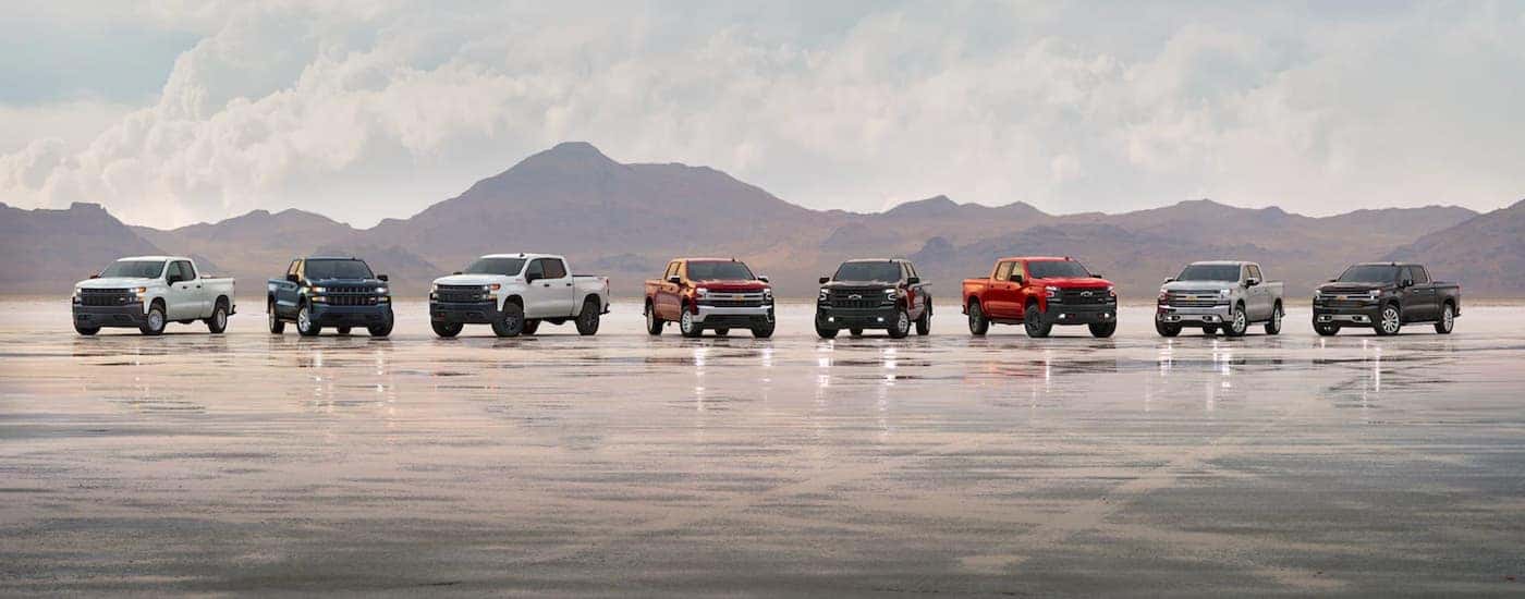 A line of 2021 Chevy Silverado 1500 diesels are parked on a runway.