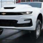 A white 2022 Chevy COPO Camaro is shown doing a wheelie at the drag strip after leaving one of the most popular Chevy dealers in NY.