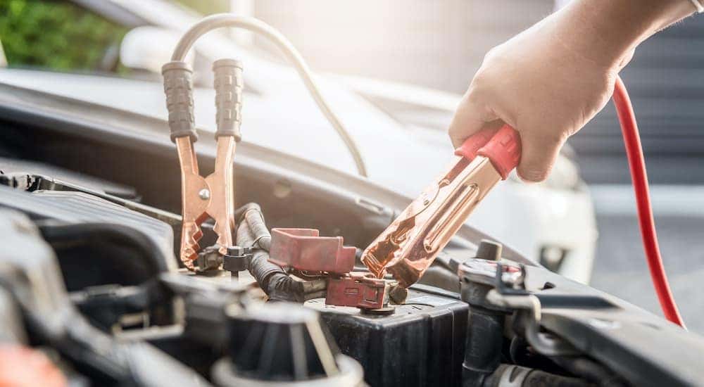 A person is jumpstarting a vehicle.