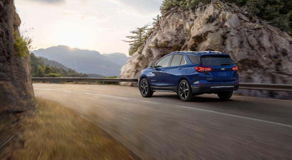 A blue 2022 Chevy Equinox Premier is shown leaving a Albany Chevy Equinox dealership.