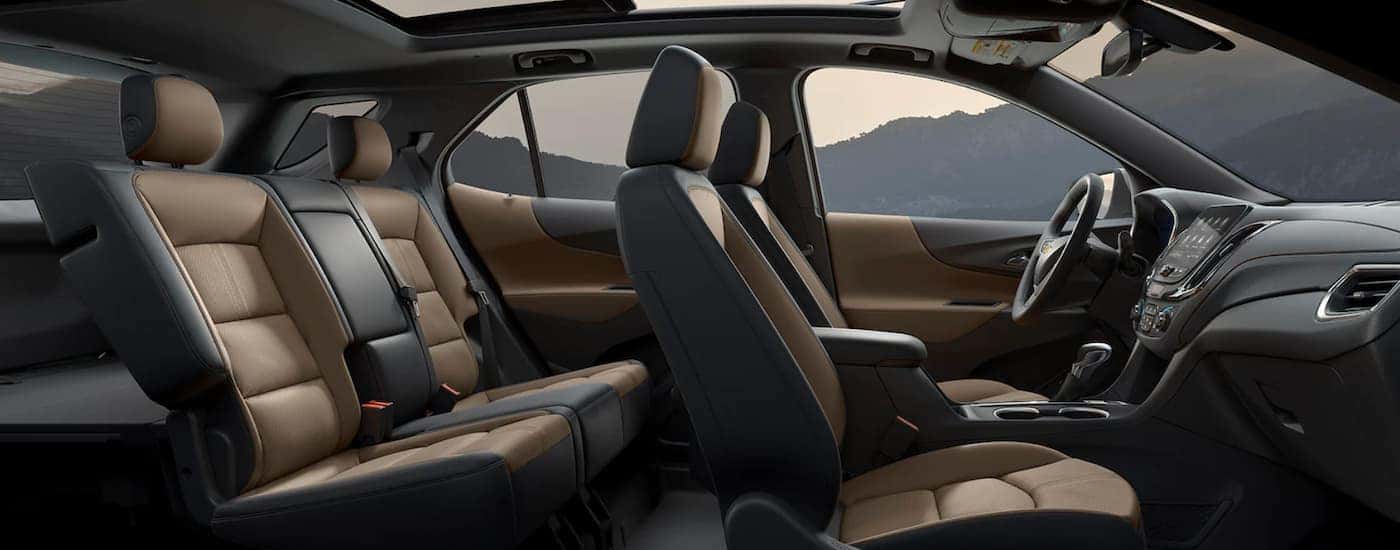 The brown and black interior of a 2022 Chevy Equinox shows two rows of seating.