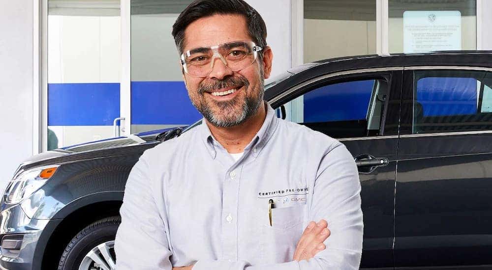 A mechanic is shown working at a certified pre-owned Chevy dealer.