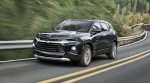 A black 2022 Chevy Blazer is shown from the front driving on an open road.