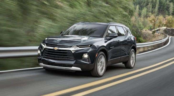 A black 2022 Chevy Blazer is shown from the front driving on an open road.