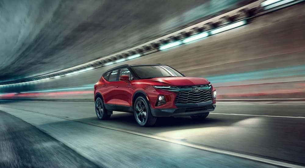 A red 2022 Chevy Blazer RS is shown driving through a tunnel after leaving a NY Chevy Blazer dealer.