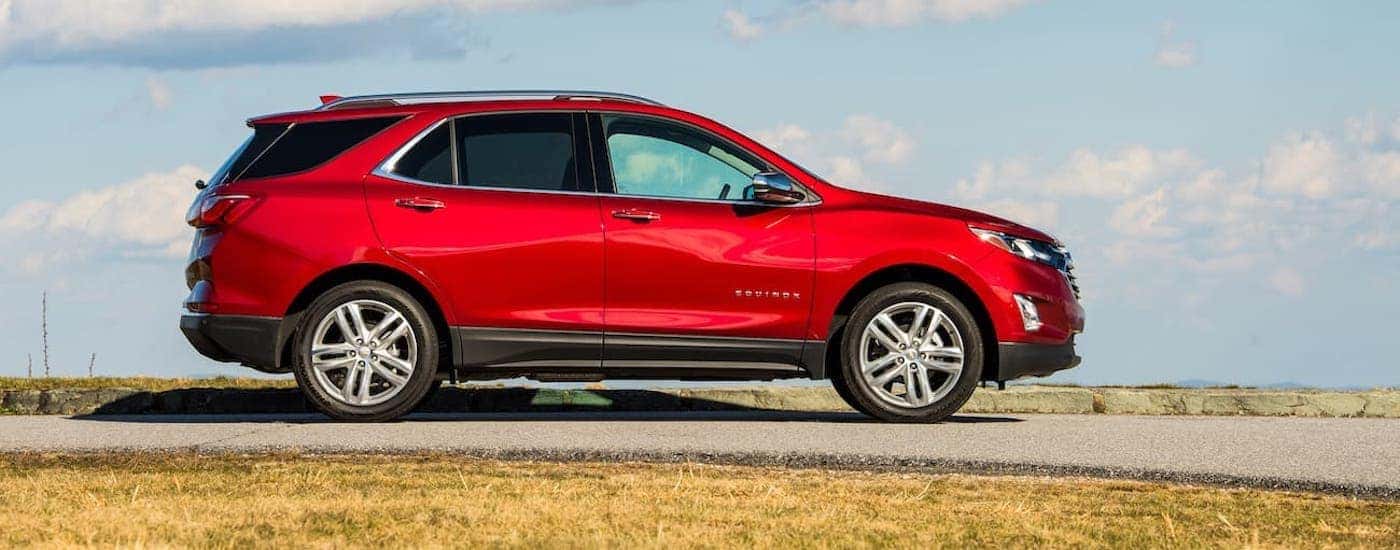 A red 2020 Chevy Equinox is shown from the side parked in a field.