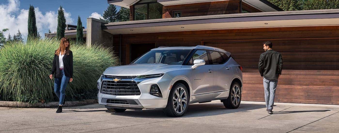 A silver 2021 Chevy Blazer is shown parked outside of a modern home.