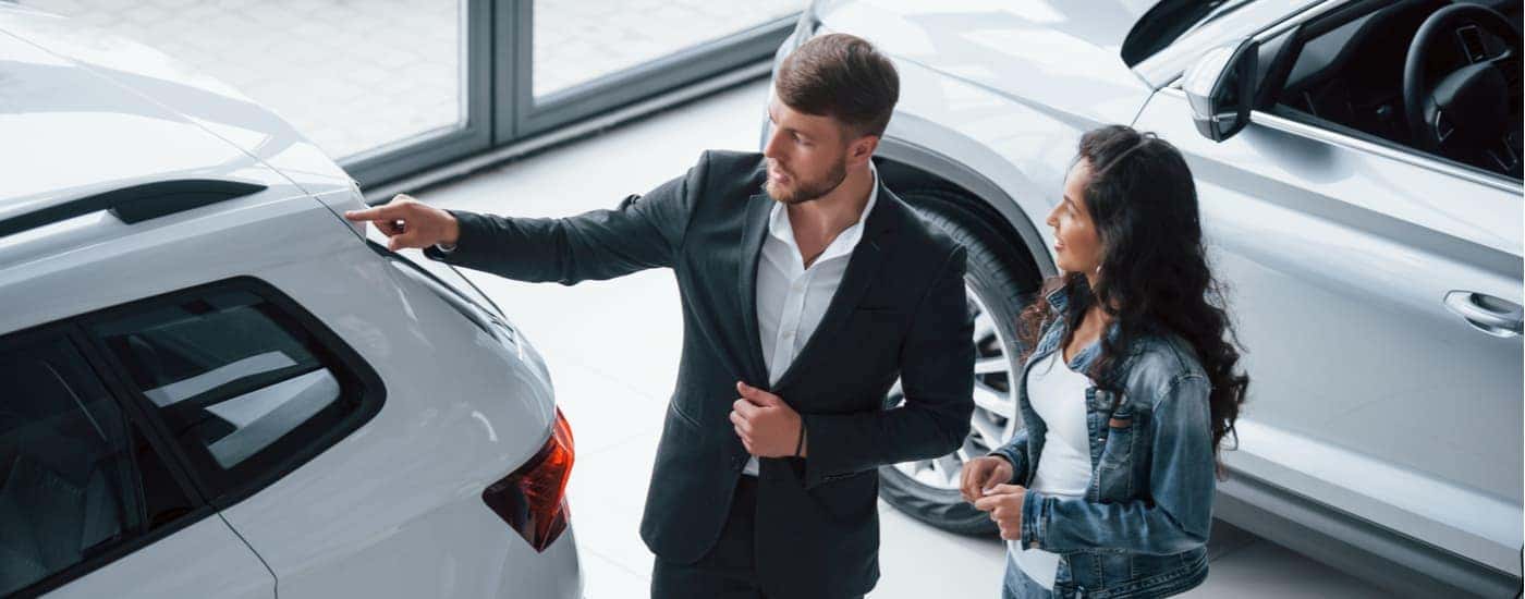 A salesman is shown speaking to a customer at a Albany certified pre-owned Chevy dealer.