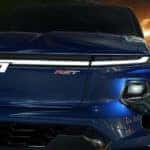 A close up shows the grille and driver side headlight on a blue2024 Chevy Silverado EV RST.