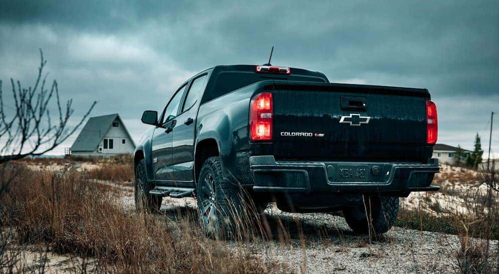 A black 2018 Chevy Colorado Z71 is shown from the rear parked on sand.