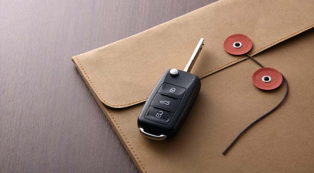 A car key is shown on top of an envelope.