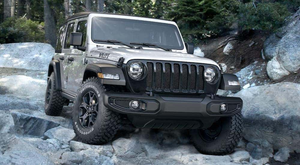 A white 2020 Jeep Wrangler Willys is shown parked on a rocks.