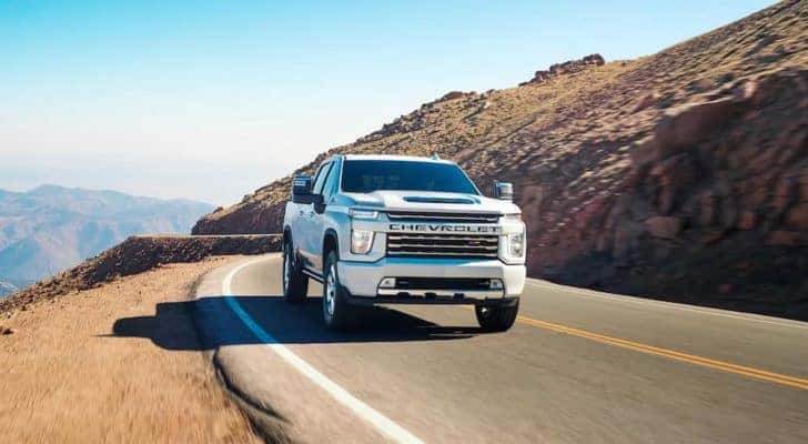 A white 2022 Chevy Silverado 3500HD LTZ is shown driving on an open road.