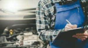 A mechanic is shown writing on a clipboard during a Chevy service.