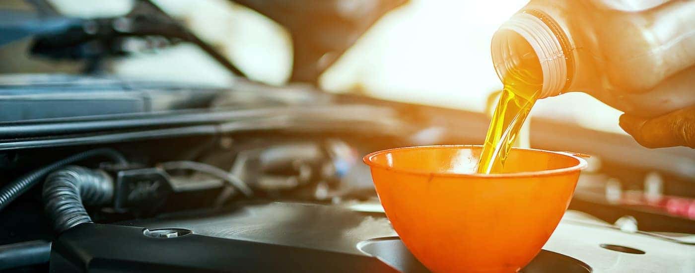 Oil is shown being poured into an engine during a Chevy service.