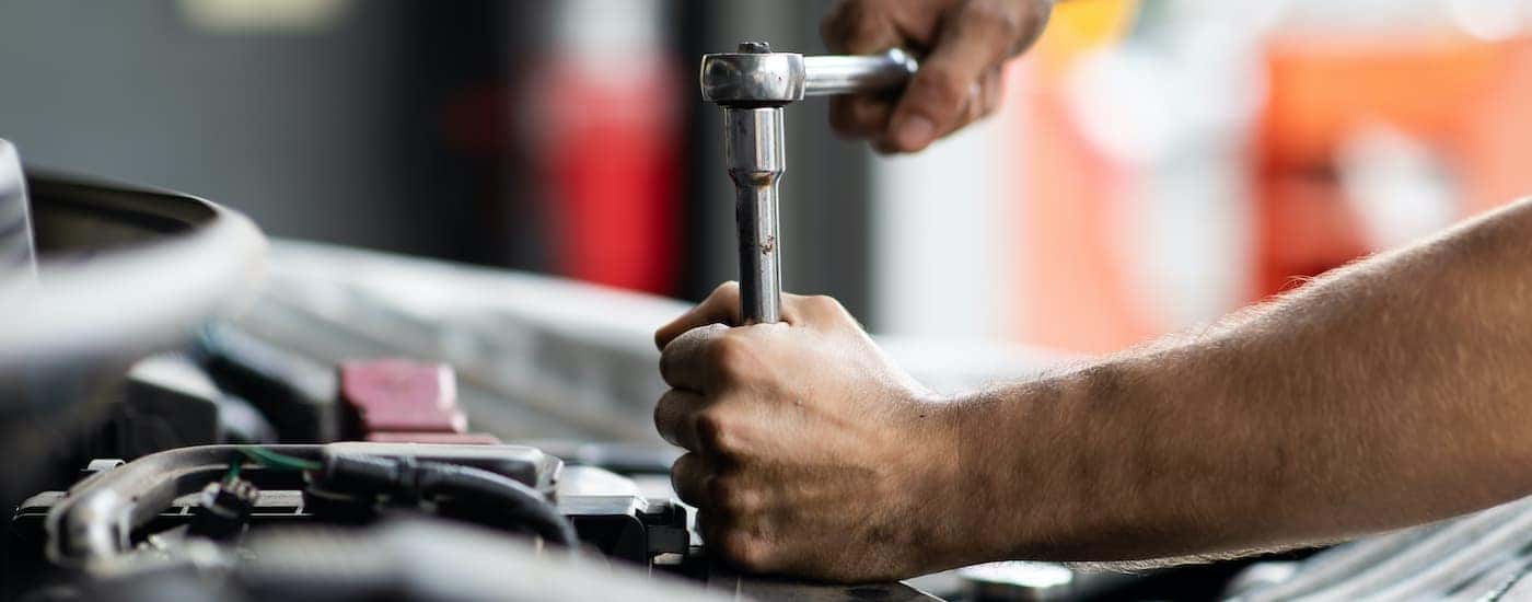 A mechanic is shown preforming a Chevy service.