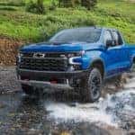 A blue 2022 Chevy Silverado 1500 ZR2 is shown driving through a river.
