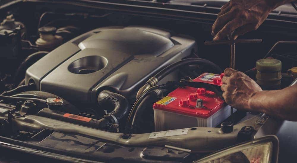 A mechanic is shown changing a battery.