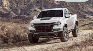 A white 2022 Chevy Colorado is shown from the front parked in the desert after leaving a NY Chevy Colorado dealer.
