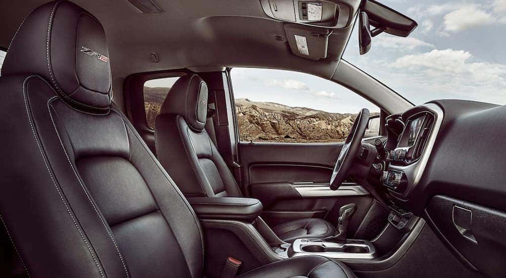 The black interior of a 2022 Chevy Colorado ZR2 shows the front seats and steering wheel.