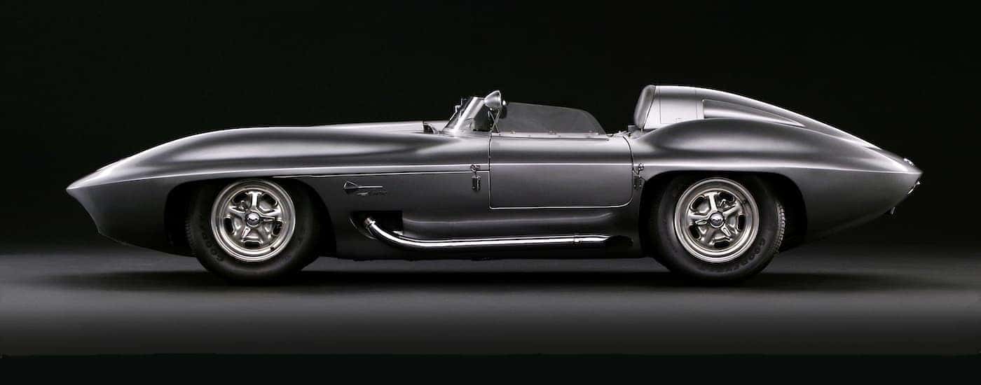 A silver 1959 Chevy Corvette Stingray Racer is shown from the side against a black background.