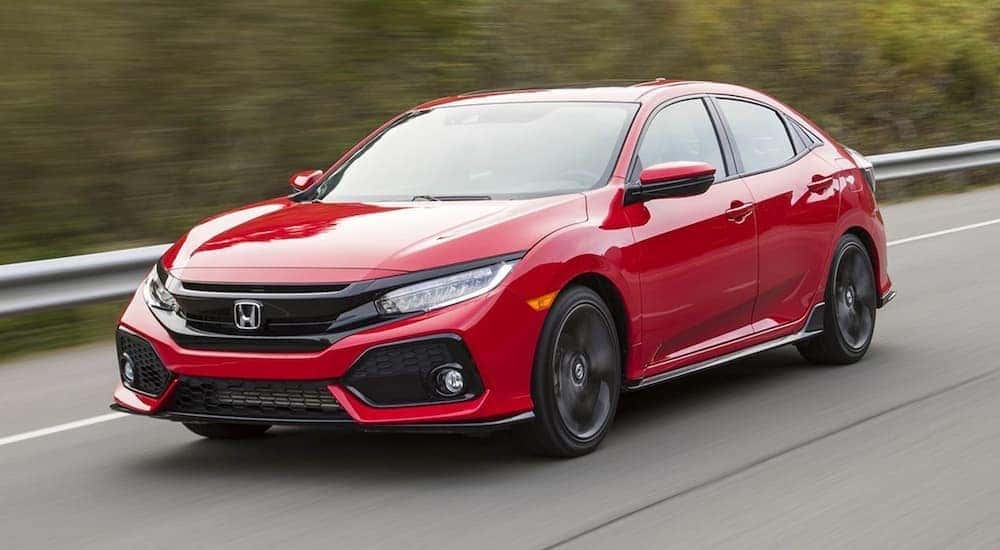 A red 2017 Honda Civic is shown driving on an open road after visiting a Troy used car dealership.