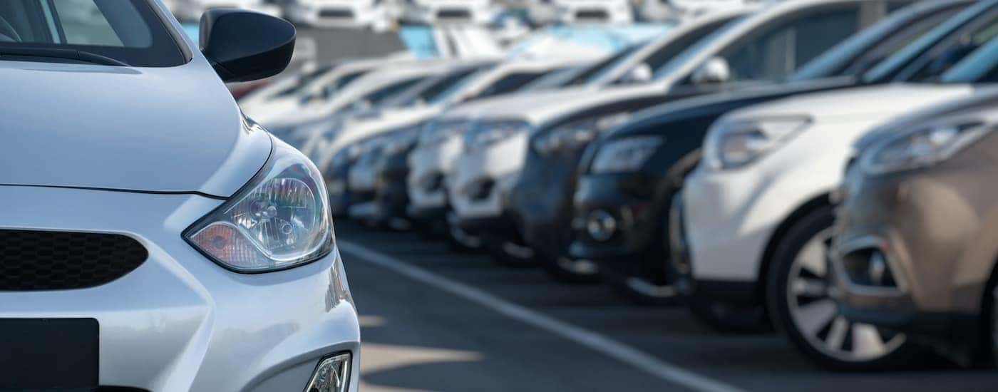 A row of used cars are shown parked at a Troy used car dealership.