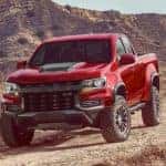A red 2022 Chevy Colorado ZR2 is shown from the front while parked in the desert.