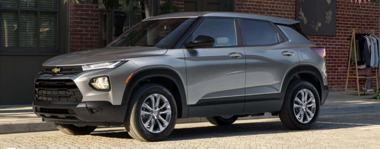 A grey 2022 Chevy Trailblazer is shown from the side parked in front of a city building.