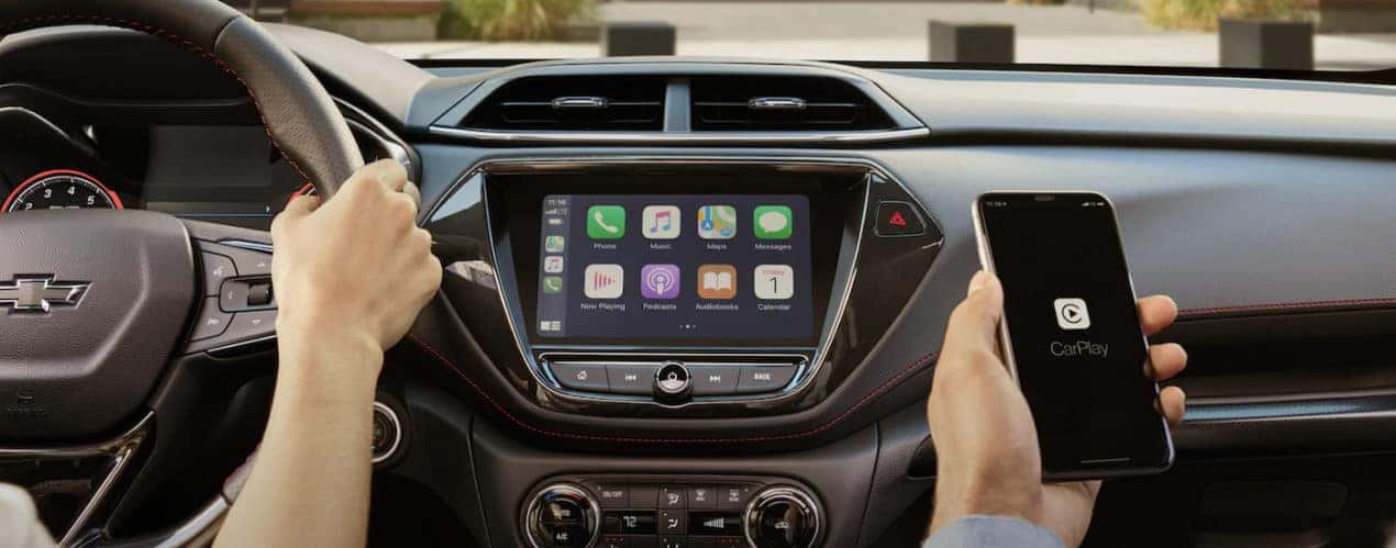 The black interior of a 2022 Chevy Trailblazer shows the infotainment screen and steering wheel.