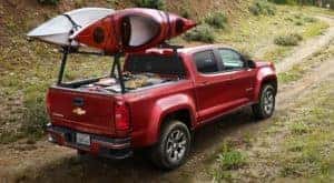 A red 2020 Chevy Colorado is shown driving on a remote dirt trail.