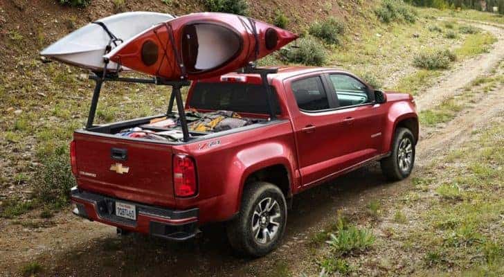 A red 2020 Chevy Colorado is shown driving on a remote dirt trail.