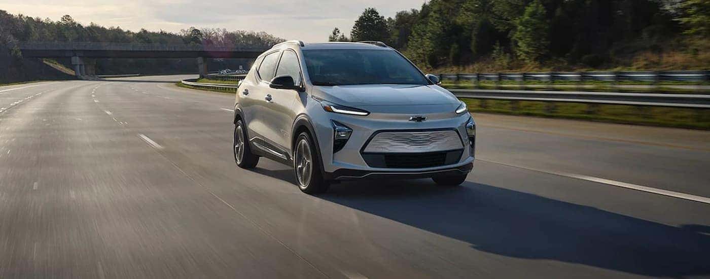 A silver 2022 Bolt EUV is shown driving on an open highway.