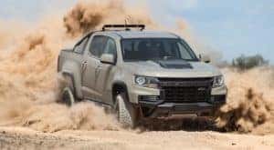 A tan 2021 Chevy Colorado ZR2 is shown from the front while drifting through sand after the owner searched 'Schenectady used truck dealers'.