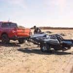 An orange 2022 Ford Maverick is shown towing a jet-ski.