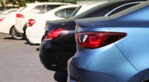 A row of used sedans are shown at a used car dealer in Clifton Park.