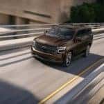 A brown 2022 Chevy Tahoe is shown from the front at an angle on an onramp.