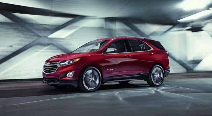 A red 2015 Chevy Equinox is shown from the side driving through a tunnel after leaving a Chevy Equinox dealer near you.